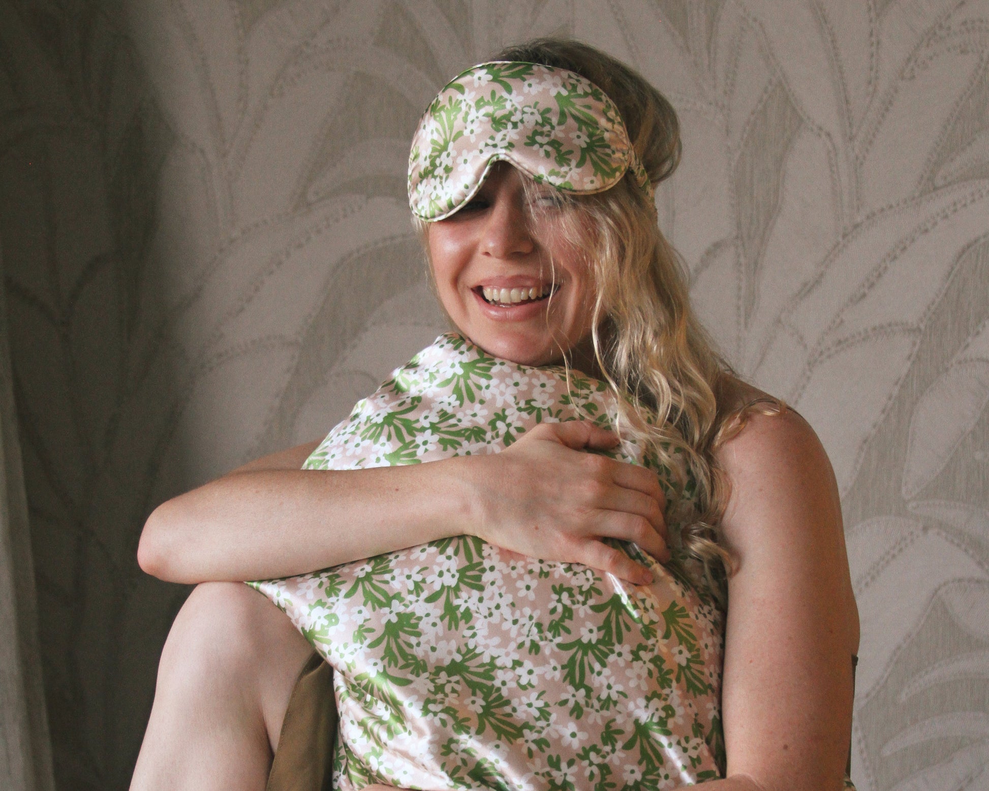 Woman wearing the floral silk eye mask and matching PillowWrap against a neutral background
